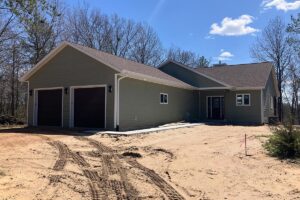 Redemption Construction general contractor in all things in home building and renovations has over 40 years experience in siding new and old home builds with sage green vinyl and brown garage doors